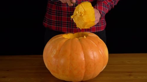 Men Carve Jack O' Lantern Pumpkin for Halloween Celebration