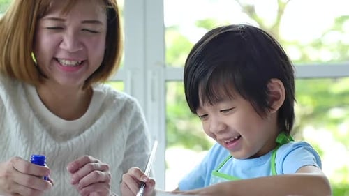 Happy Woman and Child Painting Together Indoors