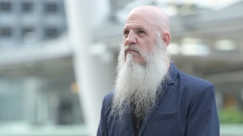 Face of Mature Bearded Bald Businessman Thinking in the City Outdoors