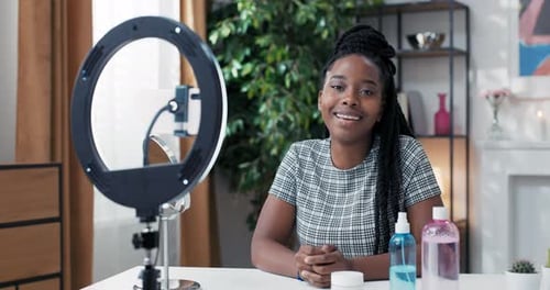 Female Influencer Sits at Desk Prepared to Record Live Streaming for Social Media Channel Tripod