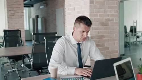 Man and Woman Collaborating on Laptop in Modern Office