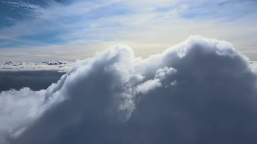 Aerial View From Airplane Window at High Altitude of Earth Covered with White Puffy Cumulus Clouds
