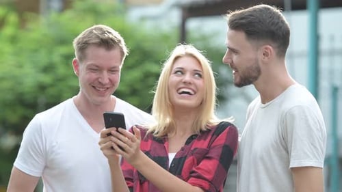 Friends Laughing Together Looking at Smartphone