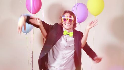 Cheerful couple dancing funny in photo booth