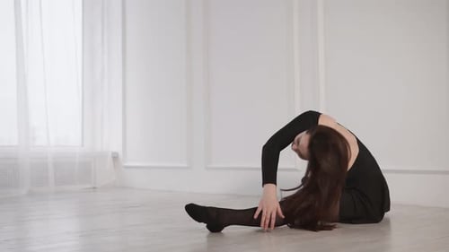 Elegant Woman Stretching in a White Studio