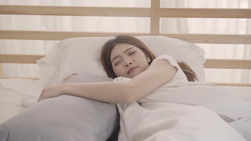 Woman Wakes Up and Stretches in Bed