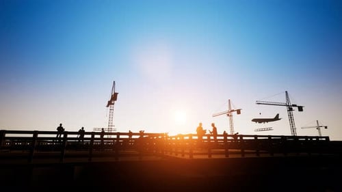 Construction Workers and Cranes Silhouette at Sunset