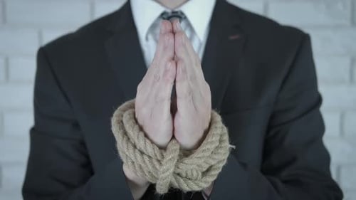 Man in Business Suit with Hands Tied