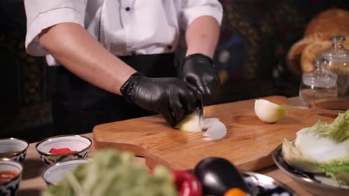 Chef Slices Onion in Professional Kitchen