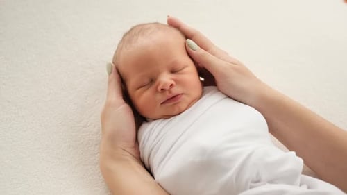 Infant Sleeping Securely in Hands Close Up