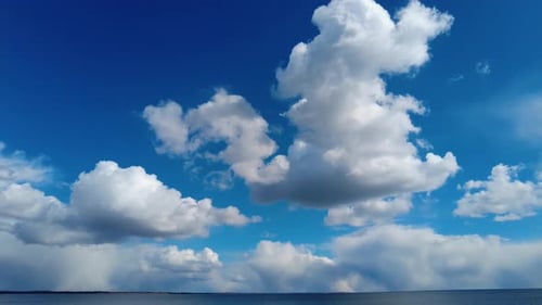 Clouds Float Over Calm Ocean Under Blue Sky