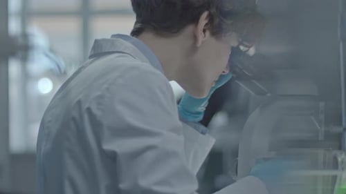 Scientist Examines Sample with Microscope in Bright Lab