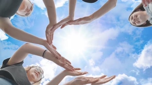 Friends Make a Circle From Their Palms Against the Background of a Fabulous Sky