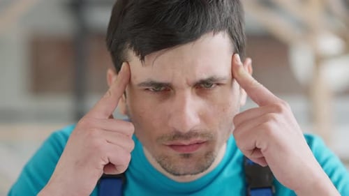 Headshot Portrait of Young Caucasian Service Man Suffering Severe Headache Indoors
