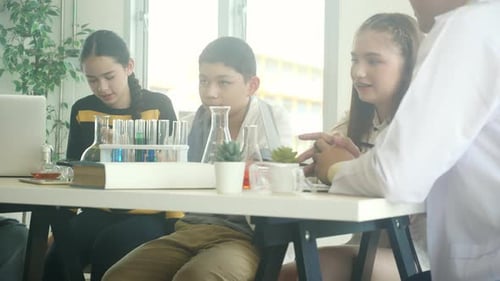 Diverse Students Working With Teacher in Science Class