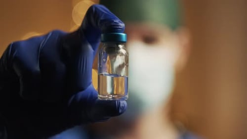 Doctor Holds Vaccine Vial in Close Up Shot