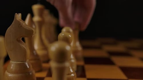 Die menschliche Hand macht den ersten Zug von White Pawn E2 E4 im Schachspiel