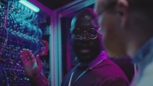 Diverse Data Center Engineers Working in Server Room