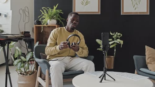 Young Adult Demonstrating Wireless Headphones in Living Room