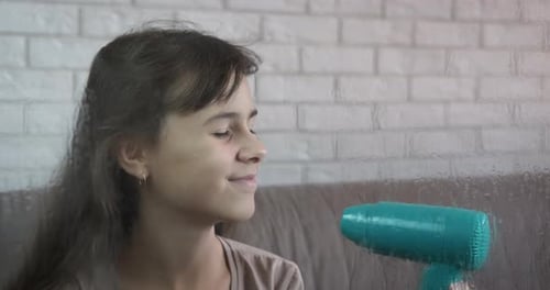 Girl Using Hair Dryer to Style Hair