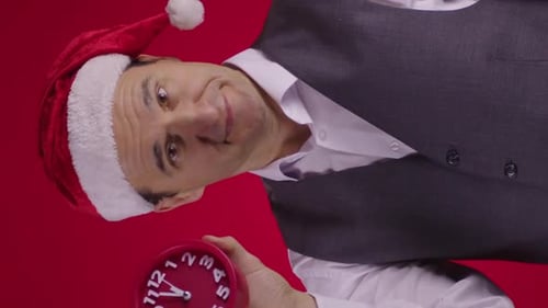 Man in Santa Hat Points at Clock