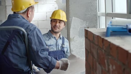 Construction Workers Discussing Plans in a Building