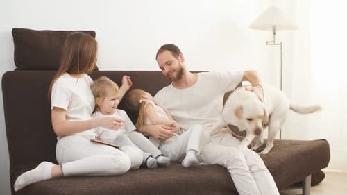 Happy Family with Dog Relaxing on Couch