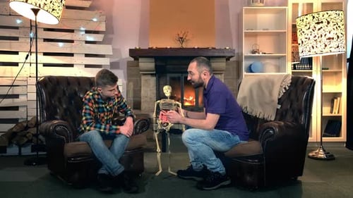 Father Explaining His Elder Son the Bone Structure of Human Body Showing on Skeleton