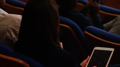 Woman Uses Tablet in Auditorium
