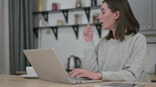 Woman Working from Home Coughing at Laptop