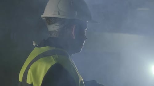 Construction Worker in Hard Hat Works in Smoke