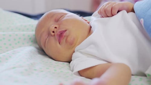 Close-up the Face of a Newborn Baby in the Early Days Who Wakes Up and Opens His Eyes. A Newborn