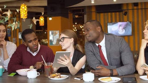 Diverse Team Collaborating at Restaurant with Tablet