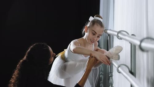 Beginner Ballerina in Tutu Teenage Girl Listens to Advice of Adult Woman Coach to Learn to Dance