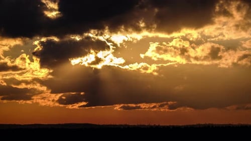 Sun Rays Shine Through Clouds at Sunset