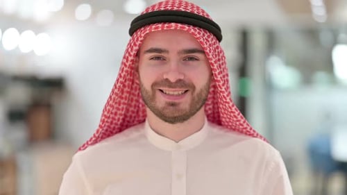 Young Man Smiling Wearing Traditional Middle Eastern Clothing