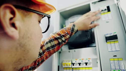 Electrician Inspecting Electrical Panel at Home