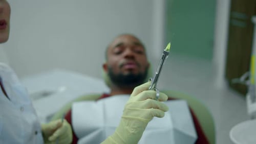 Dentista faz uma injeção em jovem