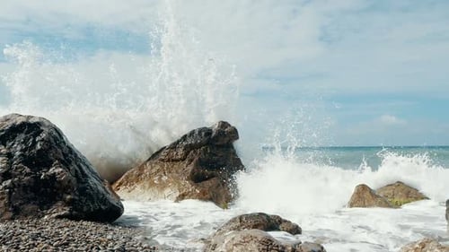 Big Wave kracht auf Steinen und spritzt. Plötzlicher Wasserspritzer. Wellen brechen auf Steinen
