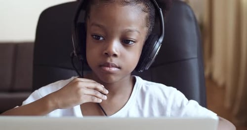 Child Using Computer and Headphones at Home