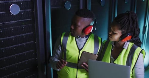 Afroamerikanische Computertechniker arbeiten mit Laptop im Business-Serverraum