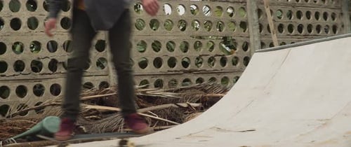 Young Adult Skateboarding on Ramp in Urban Setting