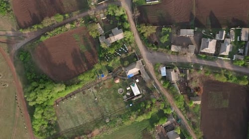 Vista aérea de casas em meio a árvores verdes e campos no campo