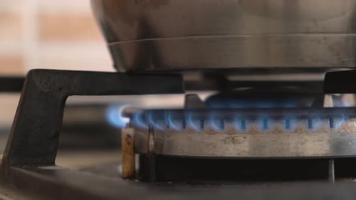 Closeup shot of blue fire from domestic kitchen stove. Gas cooker with burning flames propane gas.