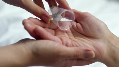 Hand Receiving Various Pills from Container Close Up