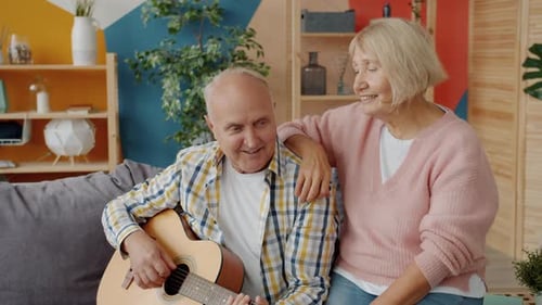 Senior Couple Relaxing, Man Playing Guitar