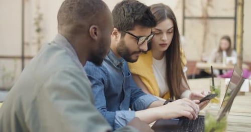 Young Adults Working on Laptop and Phone Together