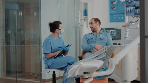 Man Speaking With Dentist in Dental Office