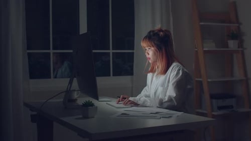 Woman Working on Computer at Desk Late at Night