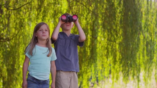 Children Exploring Nature With Binoculars on Summer Day
